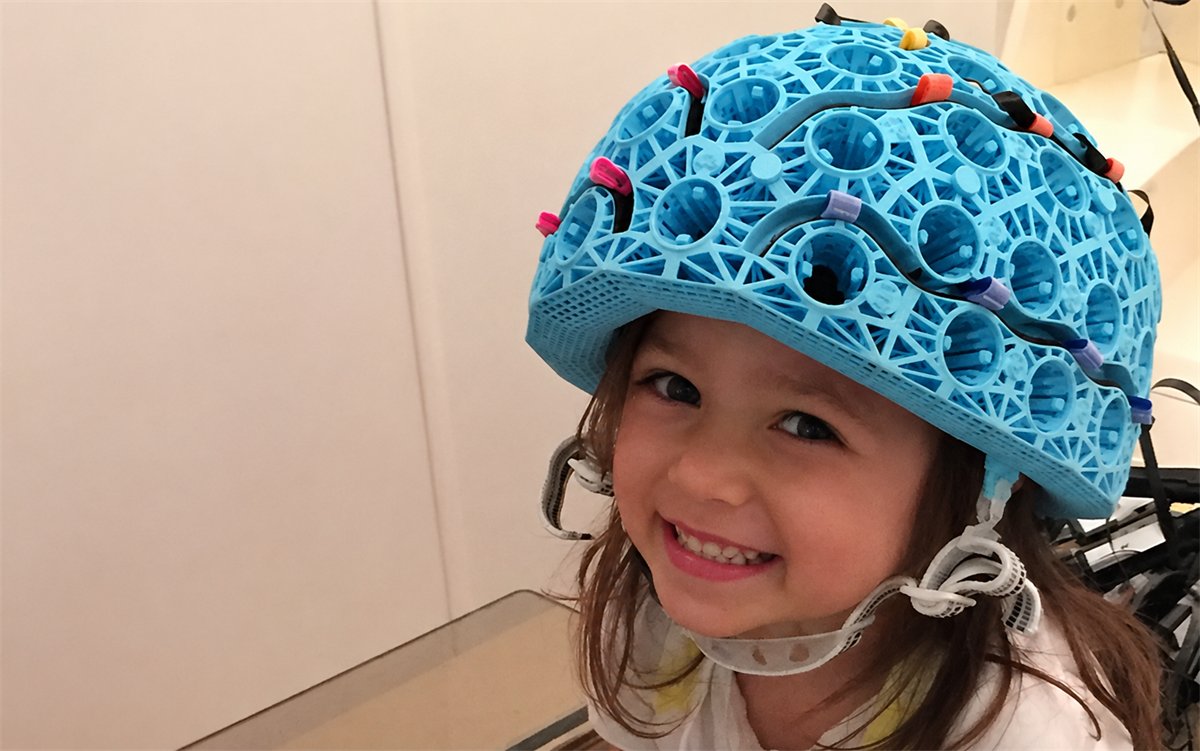 Young child wearing a lightweight OPM-MEG sensor helmet during a recording session
