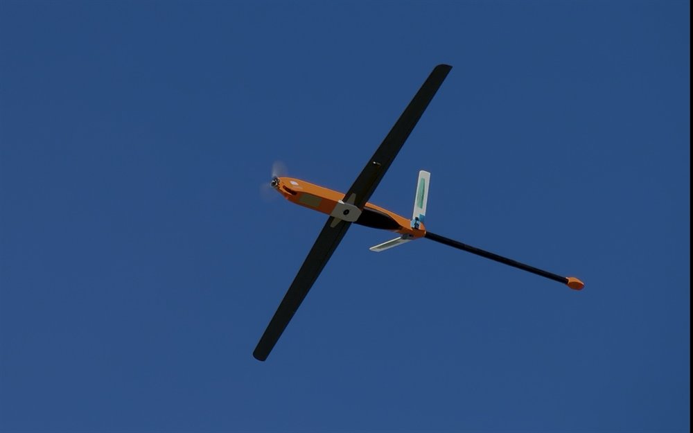 Alare MAD Wahoo fixed-wing UAV in flight with a tail-boom magnetometer